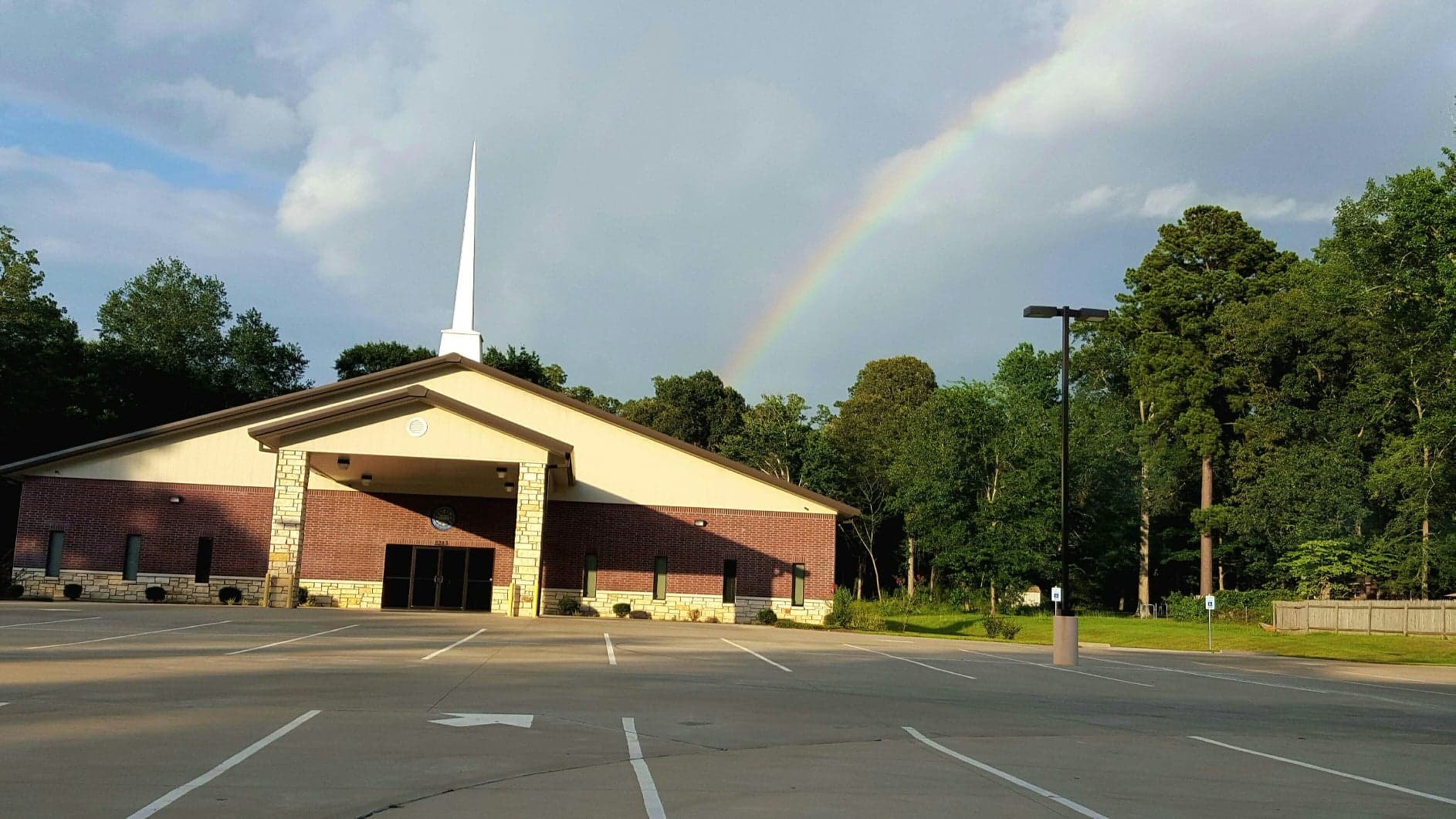 The church building on Tulane Drive with a rainbow over the trees